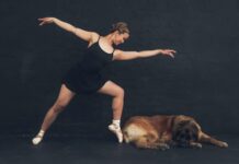 Sleep Optimization: Ultimate Secrets for the Best Rest Ballet dancer in black leotard poses elegantly beside a resting dog indoors.